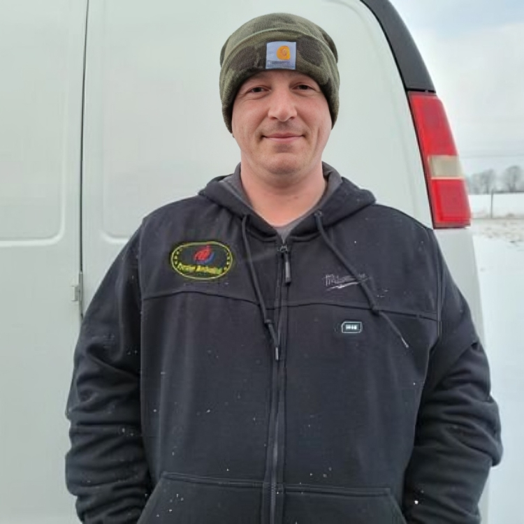 A man wearing a beanie and a black jacket is standing in front of a white van
