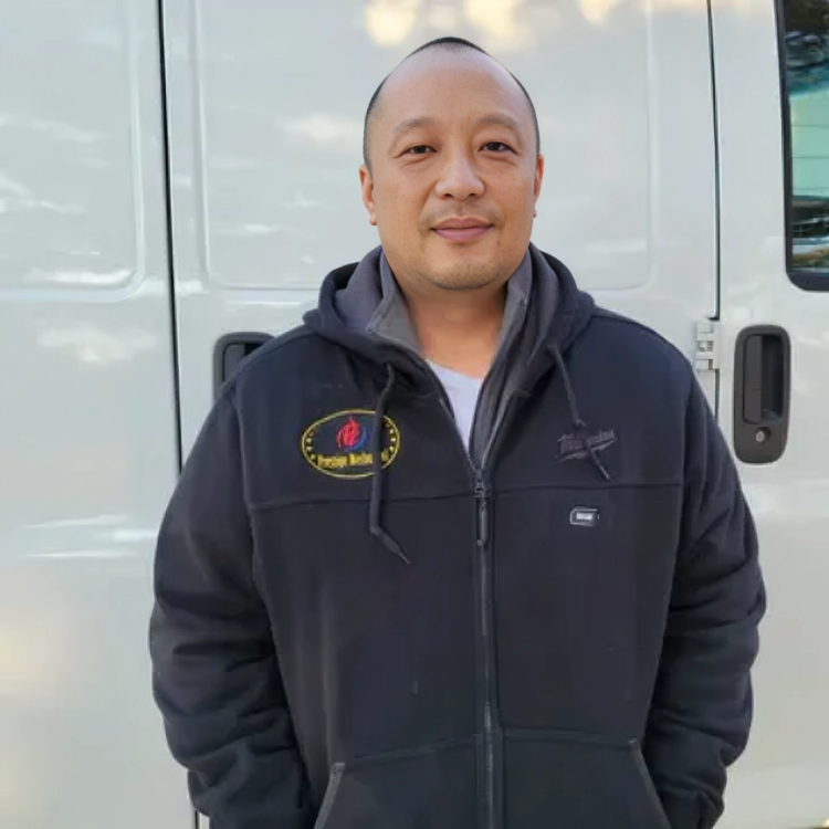 A man standing in front of a white van wearing a black jacket