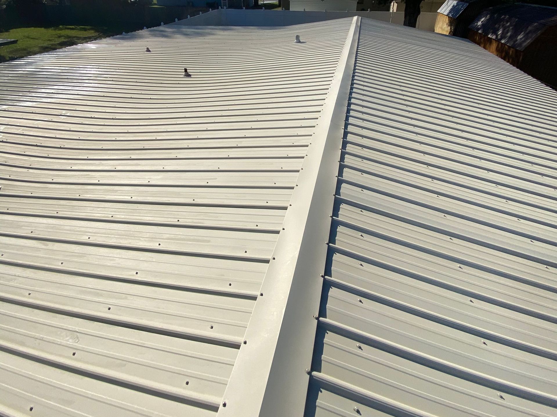 A white metal roof with a gutter on the side of it.