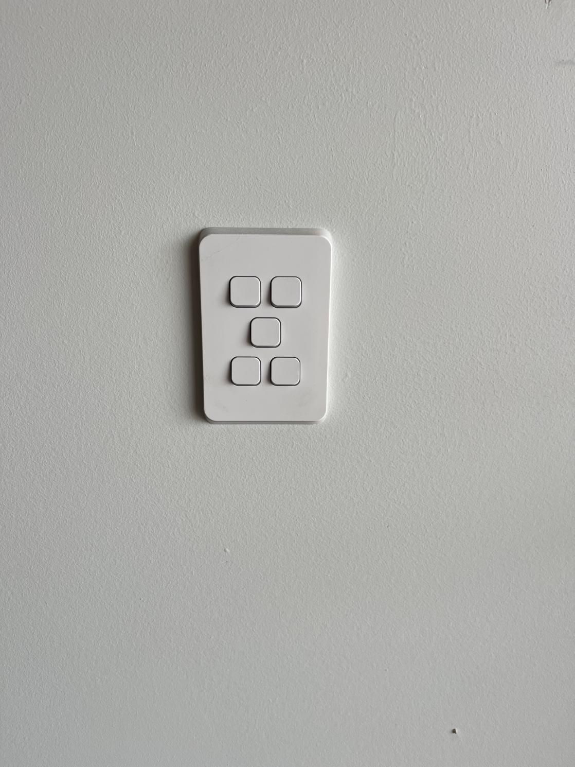 White Wall With a White Light Switch Plate Containing Five Square Buttons — JPower Energy in Kamerunga, QLD
