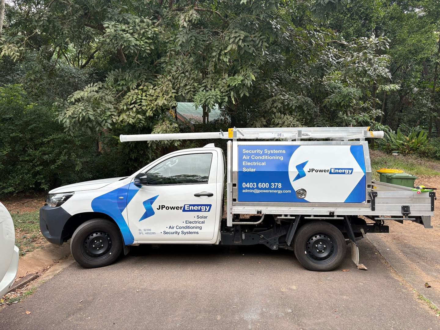 A White Service Truck With Blue Branding For J Power Energy Parked On A Driveway With Trees In The Background  — JPower Energy in Kamerunga, QLD