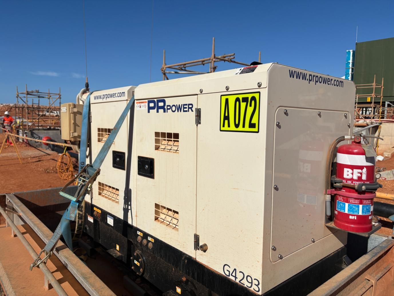 A Beige Pa Power Generator With a Fire Extinguisher at a Construction Site — JPower Energy in Kamerunga, QLD