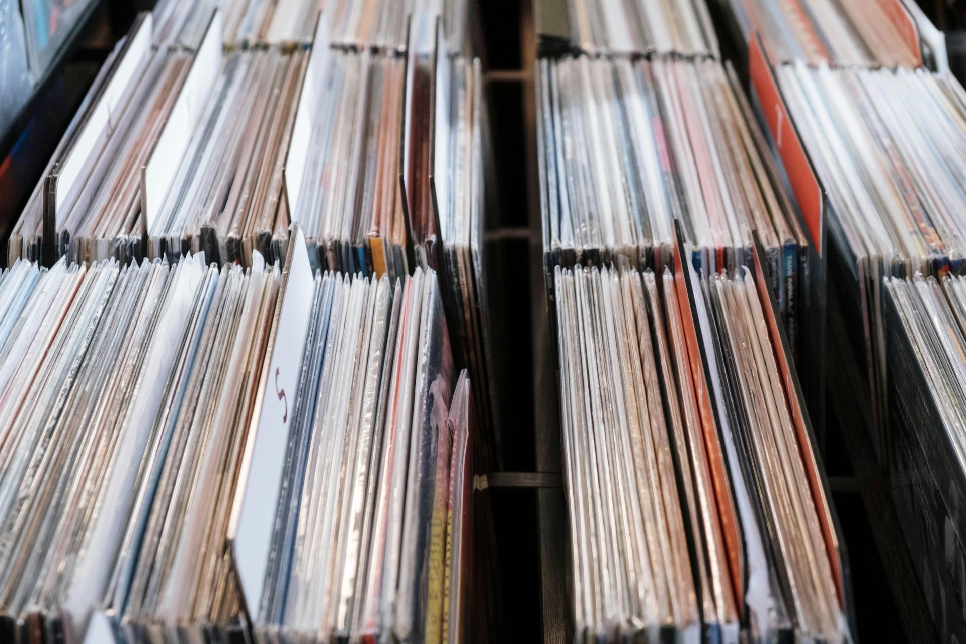 Rows of vinyl record albums filed in bins, seen from a high angle.