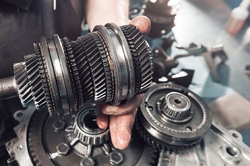 metal gear assembly over a disassembled transmission