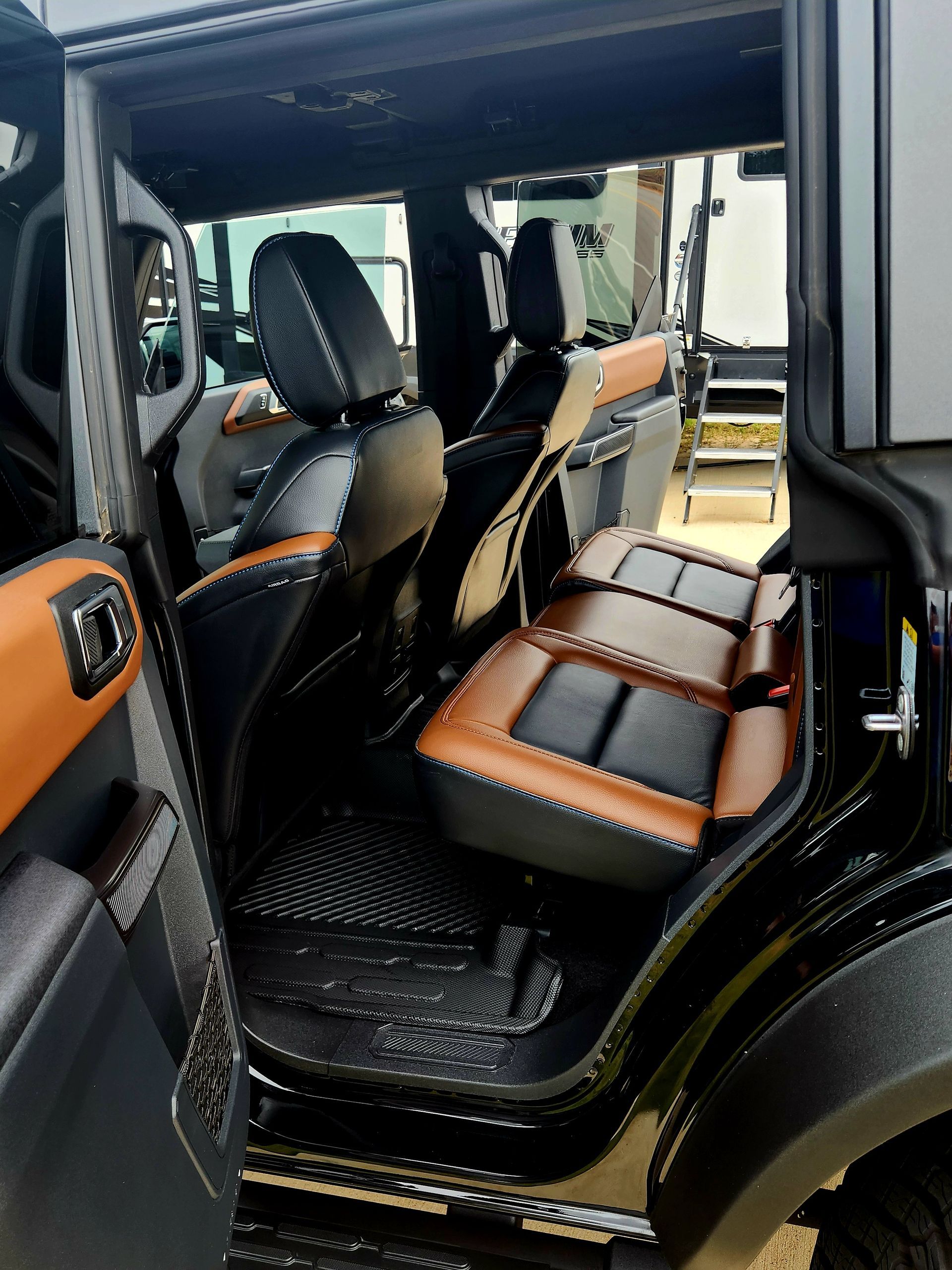 Open SUV with black and tan leather seats and doors, showing a spacious rear passenger area.