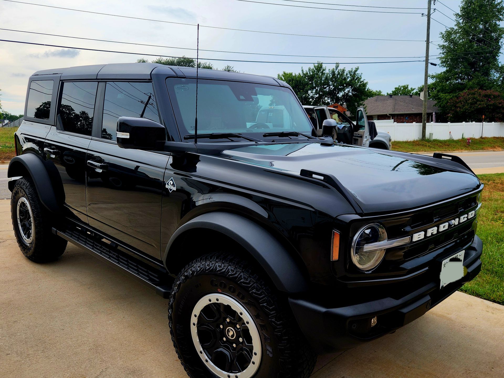 Black Ford Bronco parked on a wet street, front-left view