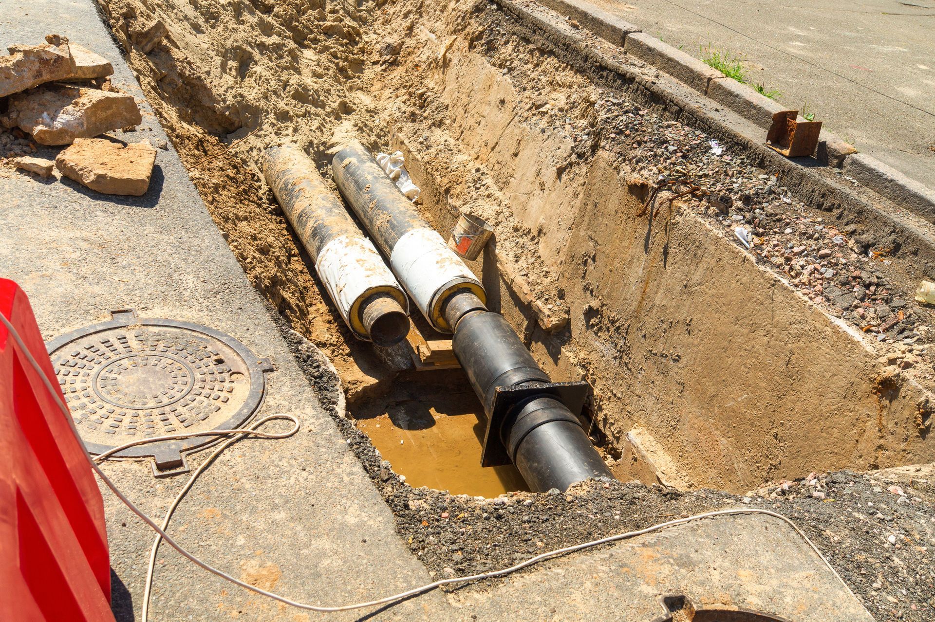 A couple of pipes are sitting in a hole in the ground.