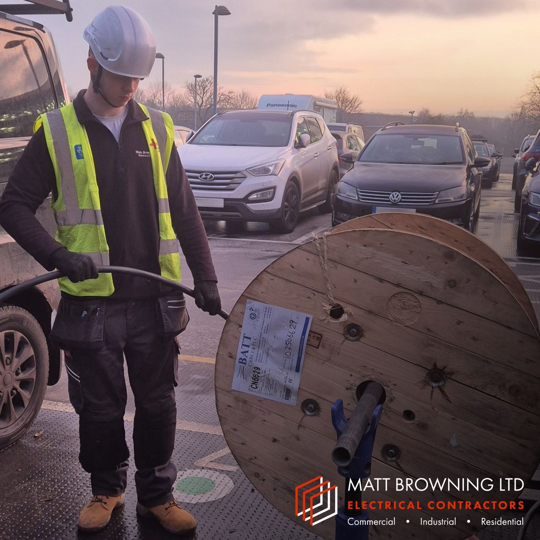 Electrical Apprentice installing SWA cable from a cable drum to feed workplace EV chargers in Bracknell