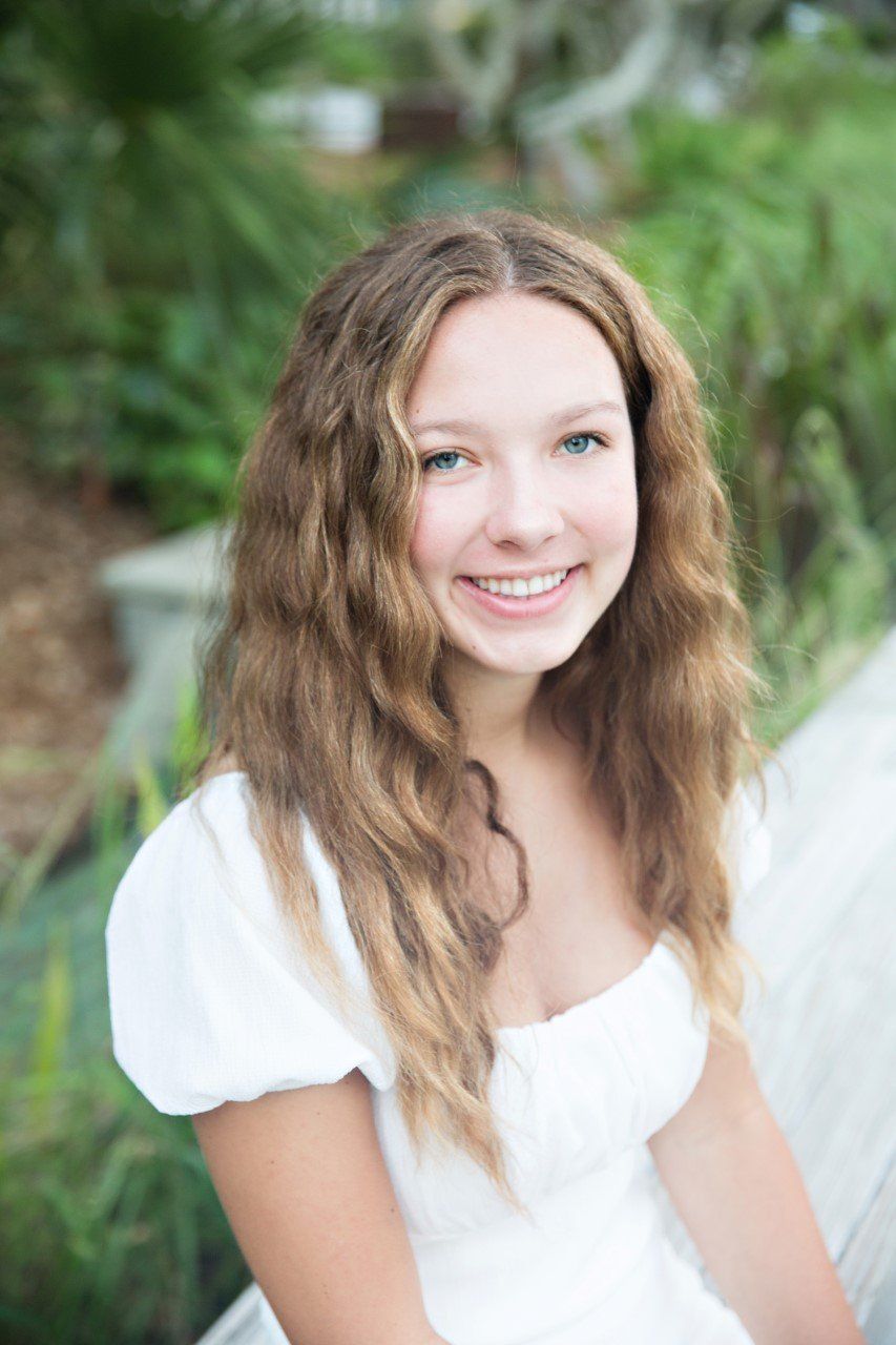 Image of beautiful Chloe with big blue eyes wearing a white dress.
