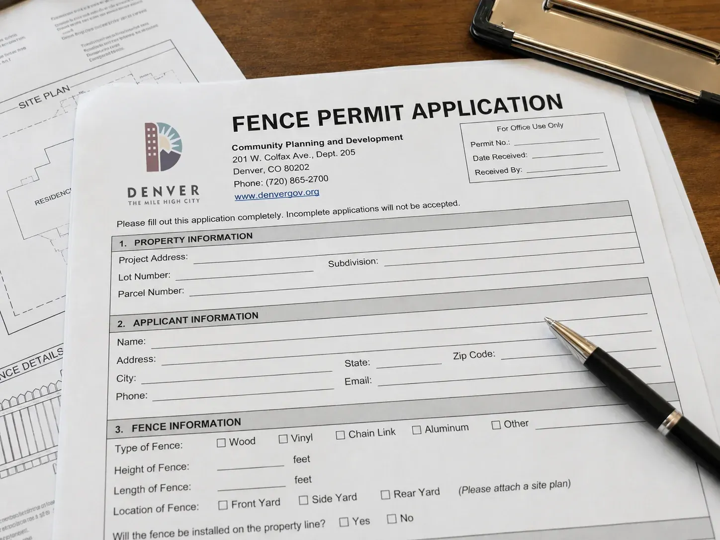Fence permit application form on a desk with a pen and papers in the background.