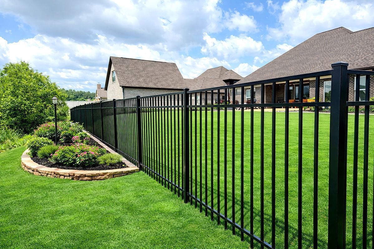 black ornamental fence following a sloped landscaped yard
