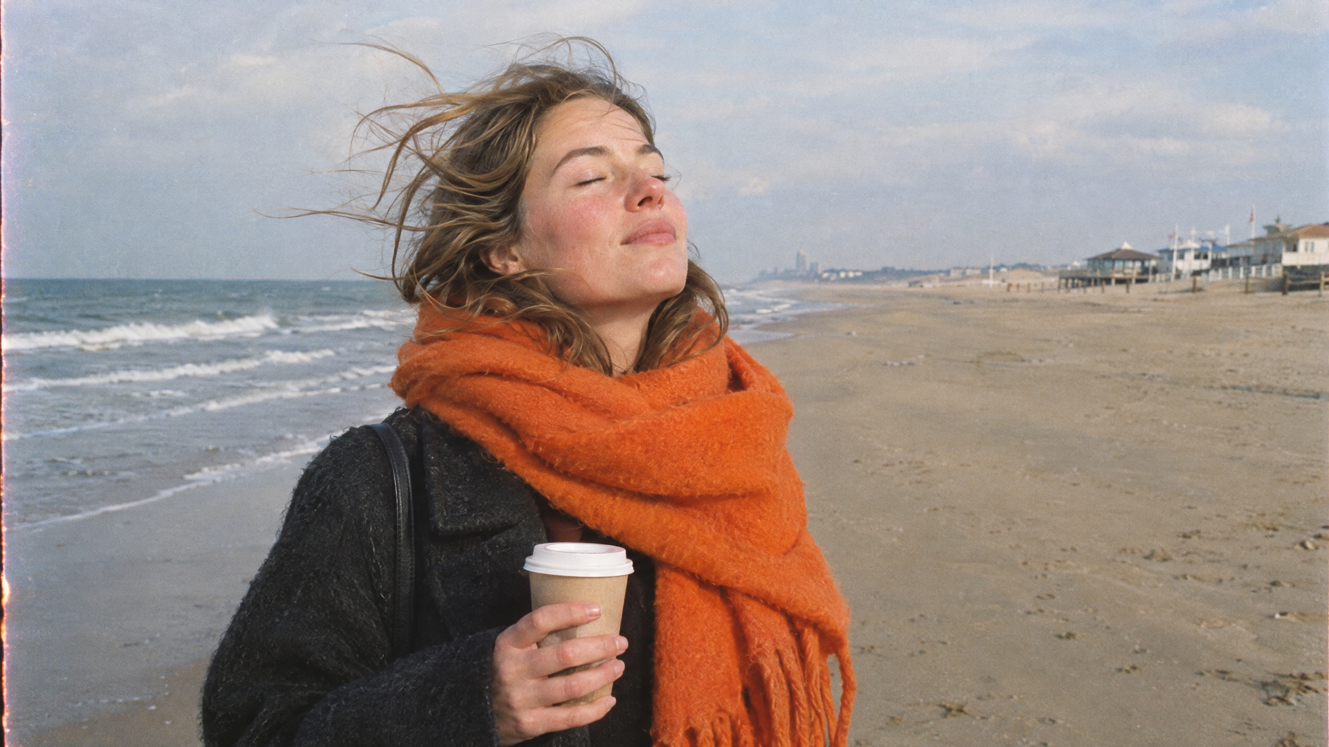 Vrouw met een beker koffie op het winterstrand van Zandvoort