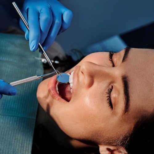 A man is getting his teeth examined by a dentist.