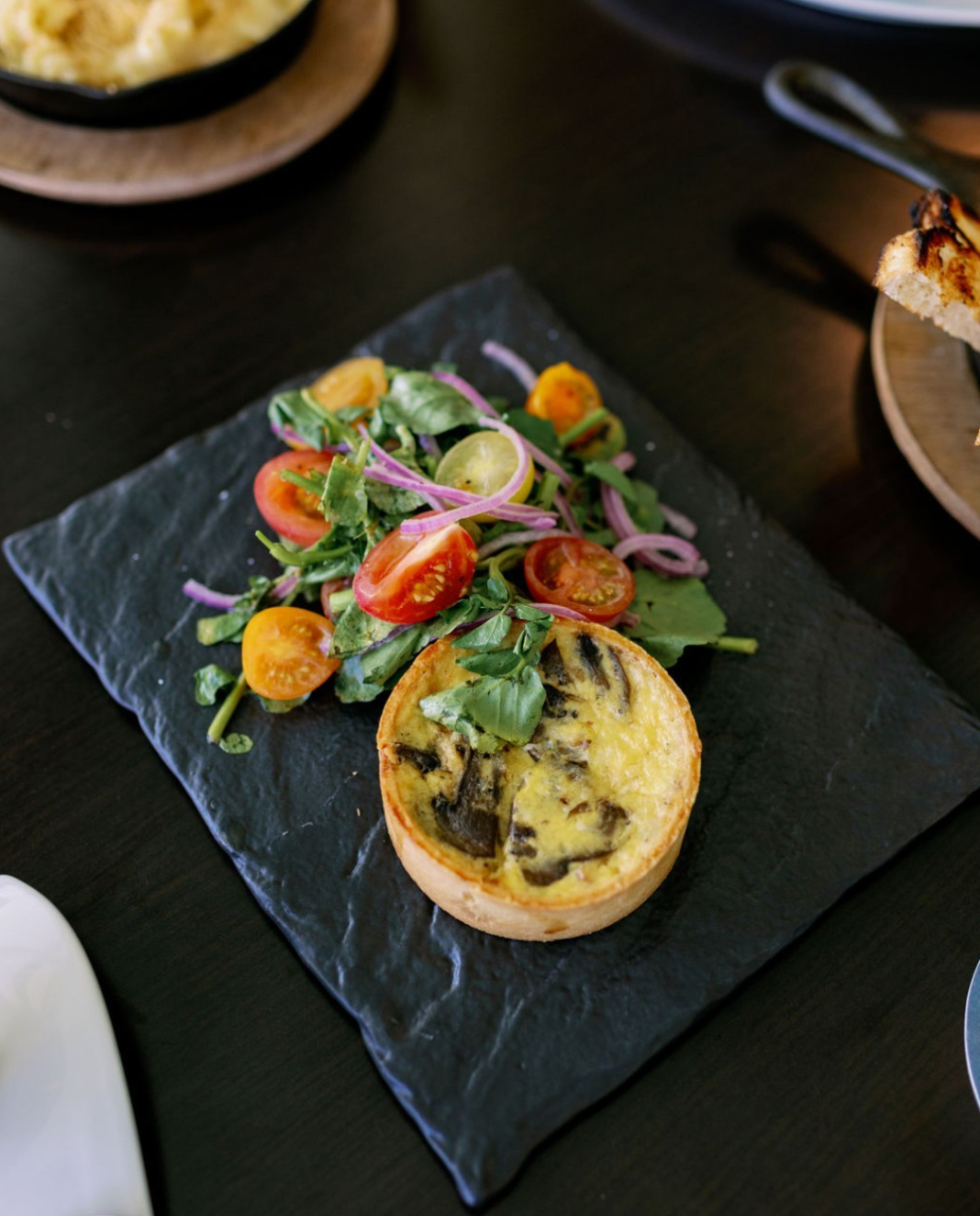 A plate of tomatoes and a quiche on the table at Covey Kitchen Restaurant.