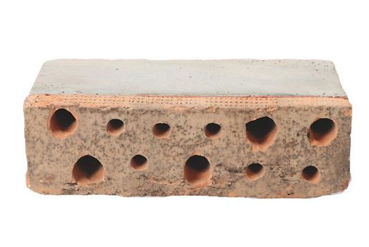 Pale brick with multiple round holes across the front face