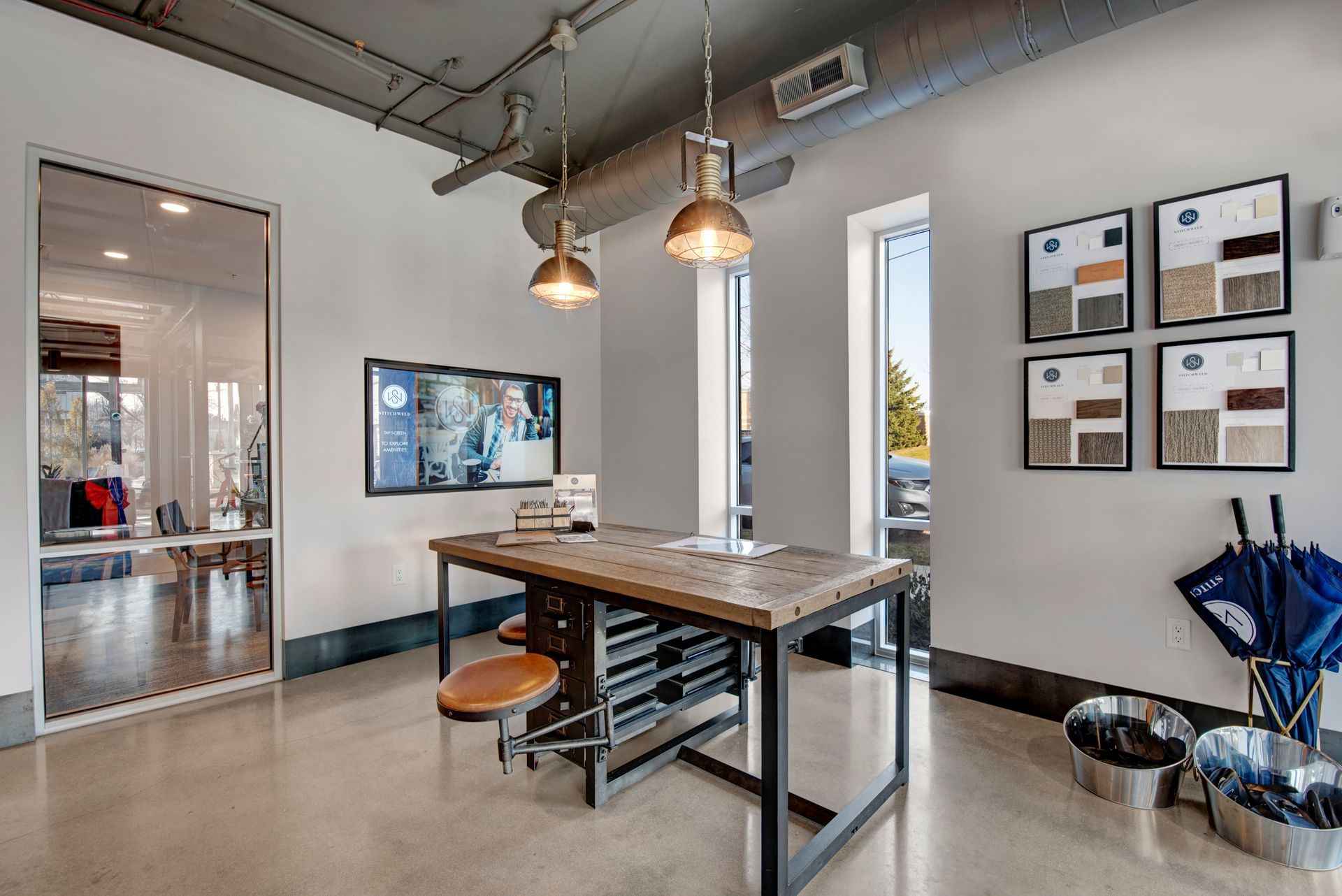 A room with a table , chairs , umbrellas and a television.