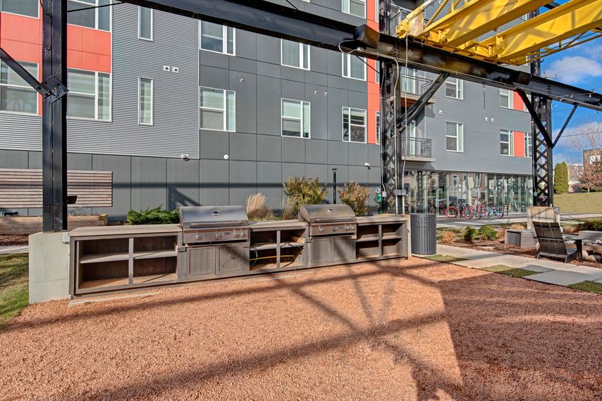 A large building with a lot of windows and a grill in front of it.