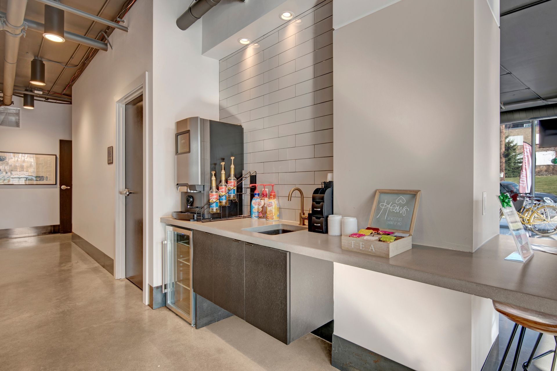 A kitchen with a counter and a refrigerator in a building.