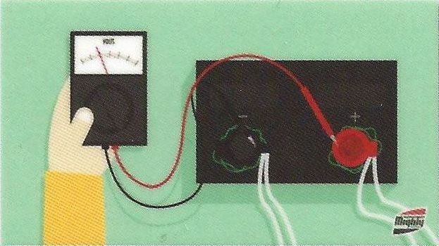 A person is holding a multimeter next to a circuit board