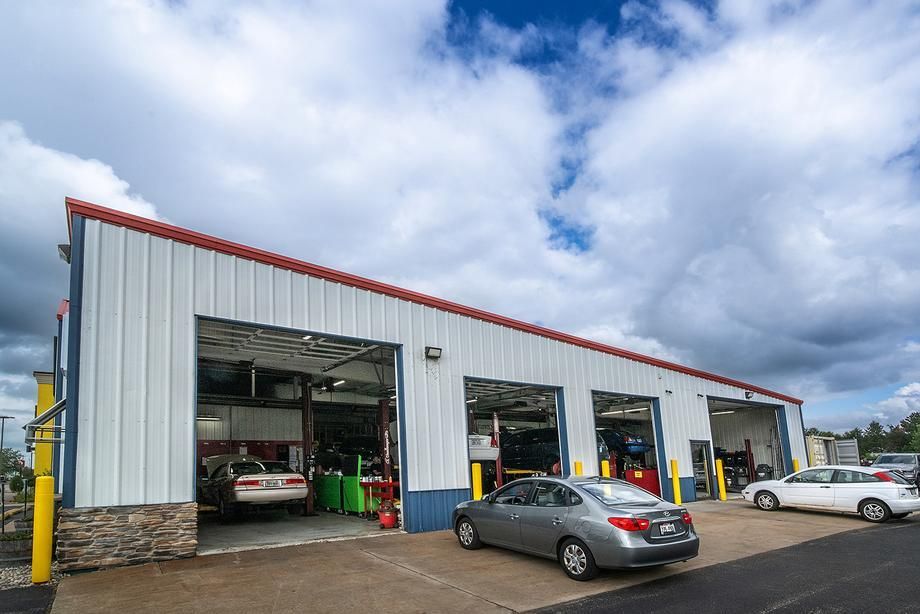 A garage with cars parked in front of it on a cloudy day.