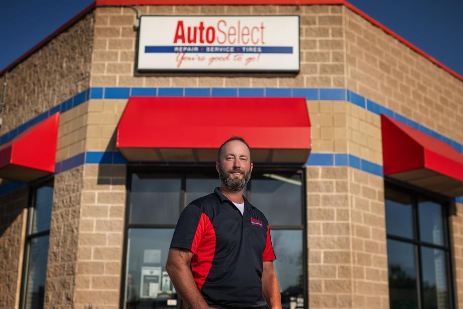 A man is standing in front of an autoselect store