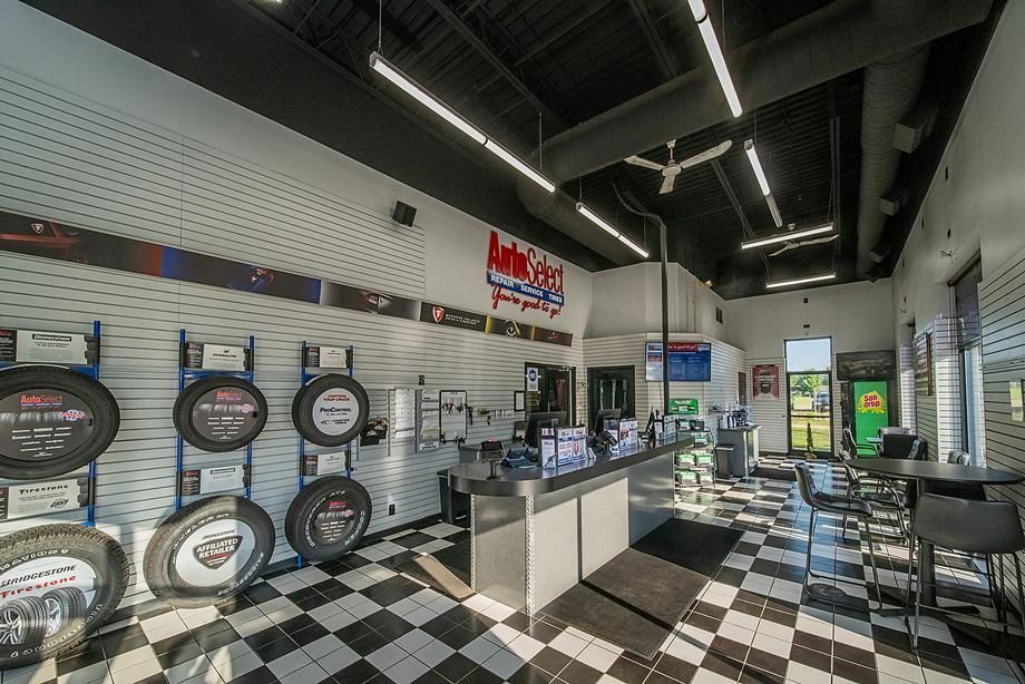 The inside of a tire store with a checkered floor and tires on display.