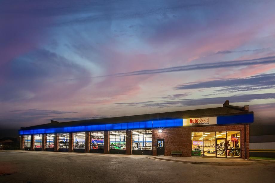 A large brick building with a blue awning is lit up at night.