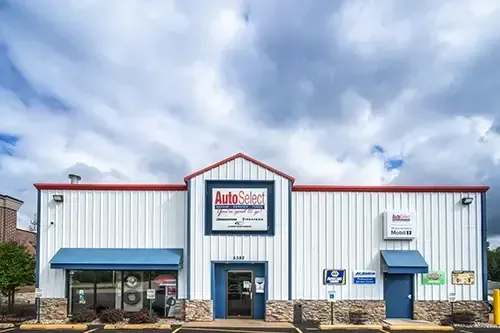 A white building with a blue awning and a red roof.