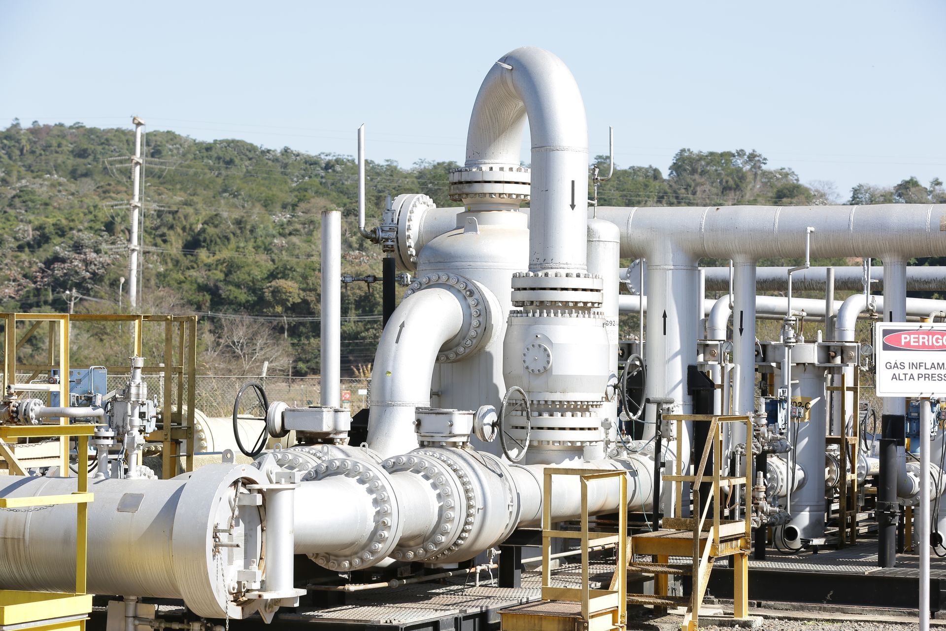 A lot of pipes and a sign that says danger