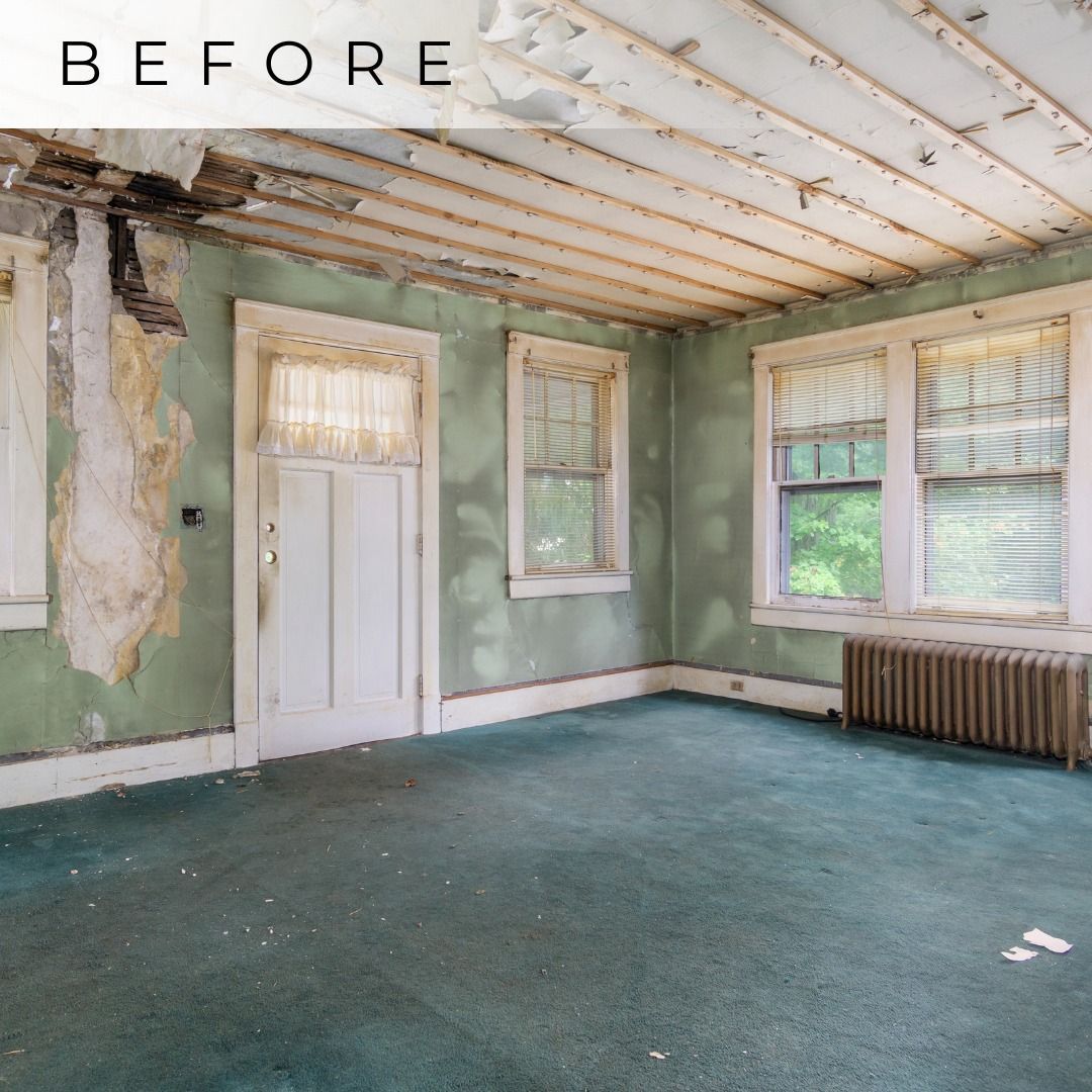 Deteriorated empty room with peeling green walls, exposed ceiling, and worn blue carpet.
