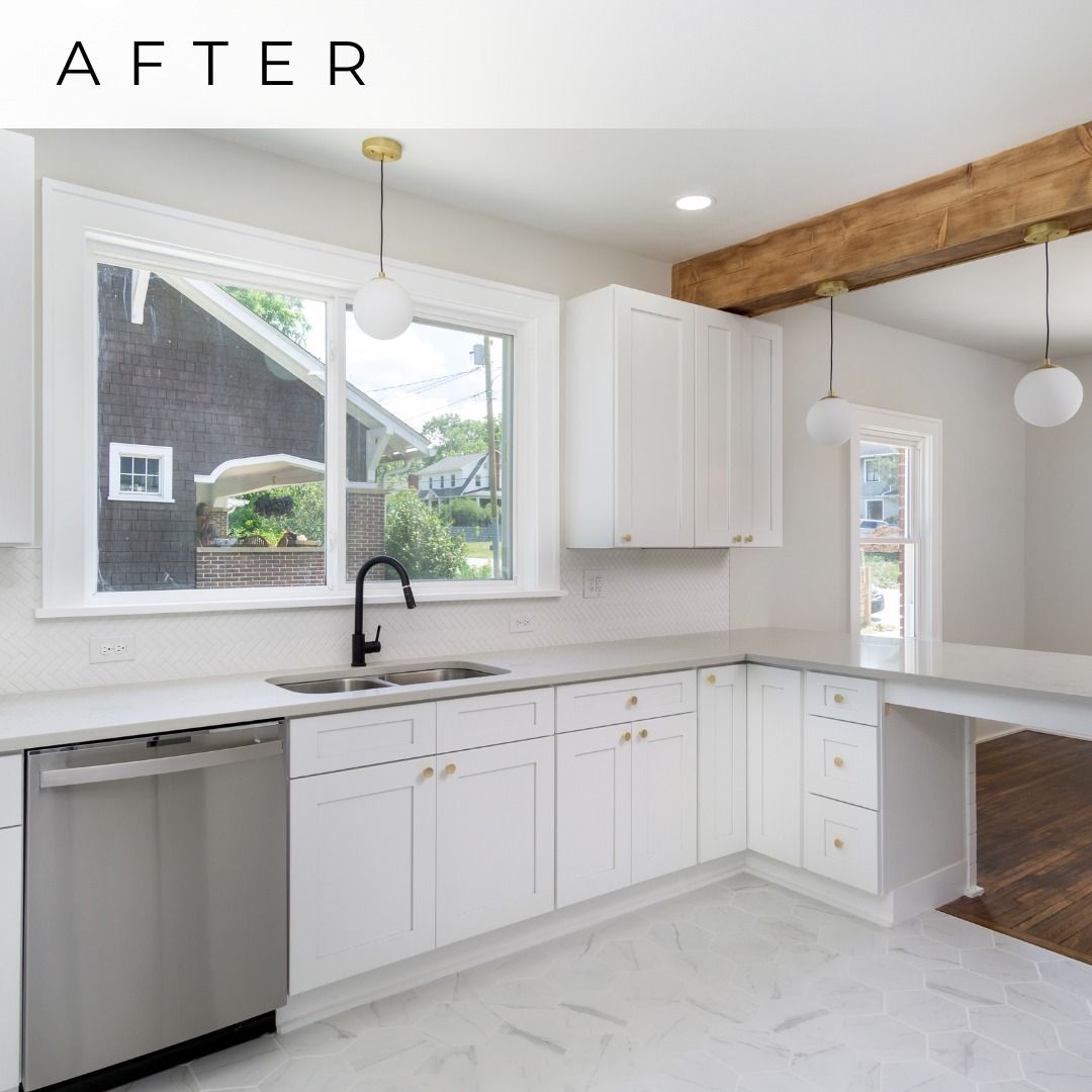 Bright white renovated kitchen with black sink, wood beam, stainless dishwasher, and large window