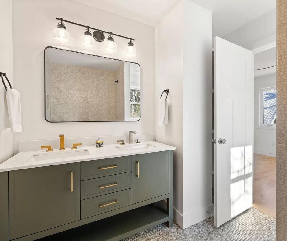 Modern bathroom vanity with gray cabinets, white sink, mirror, and bright lighting