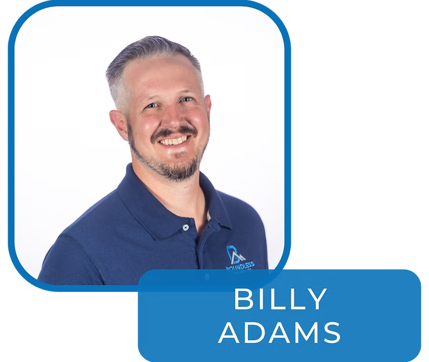 Portrait of Billy Adams in a blue polo shirt with a blue name label on a white background
