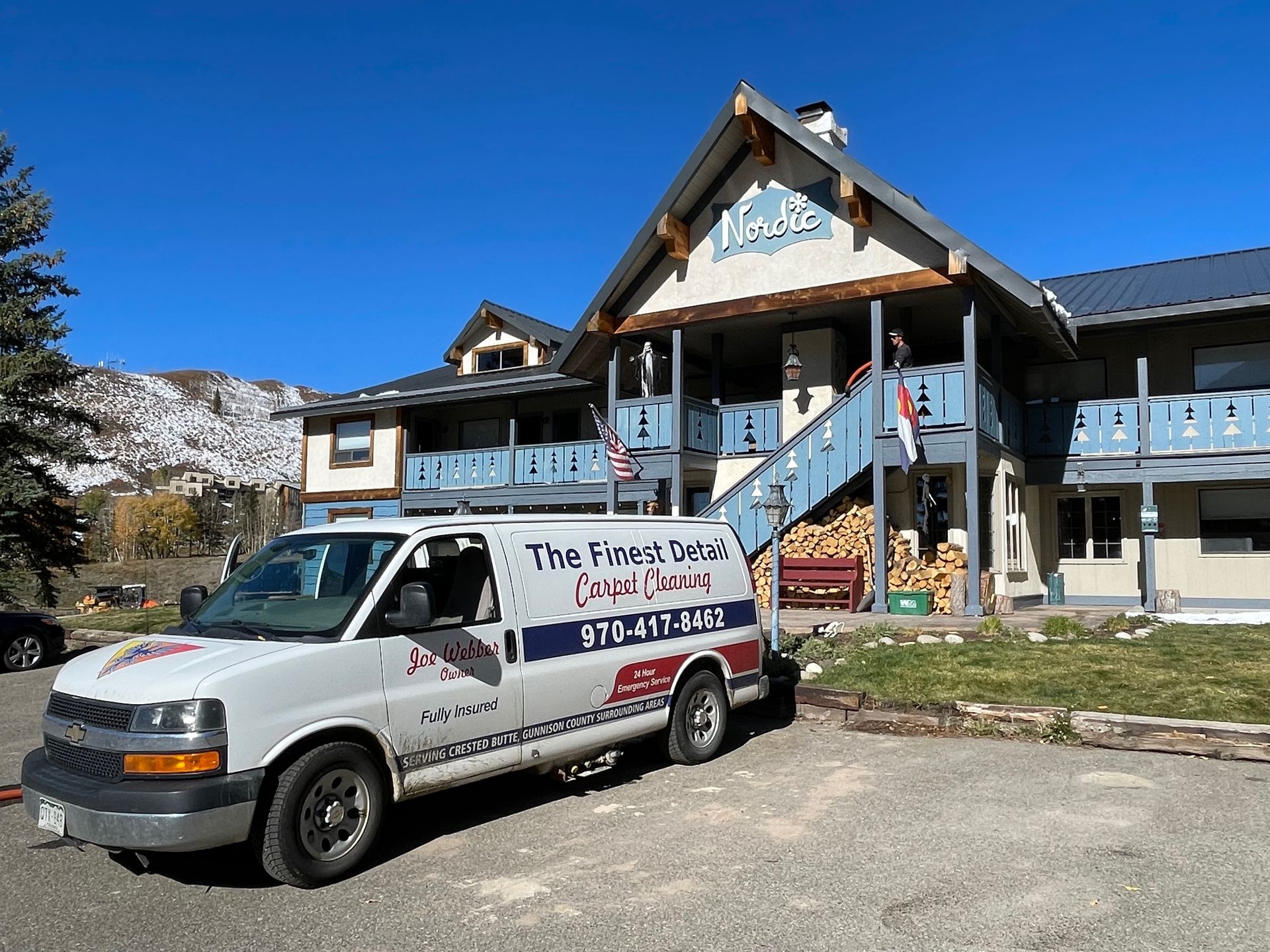 A white van is parked in front of a building.