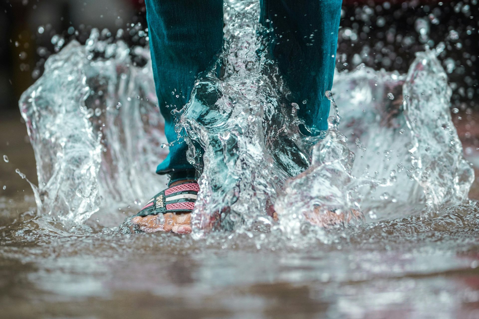 A person is jumping into a puddle of water.