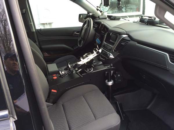 Interior of a police vehicle, with the driver's seat and center console visible. 
