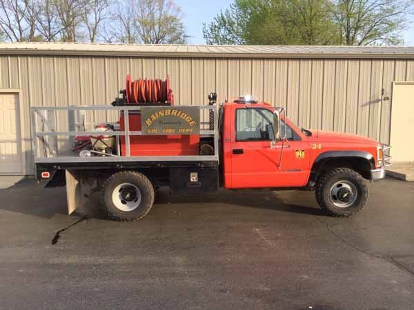 Red fire truck with a flatbed, labeled 