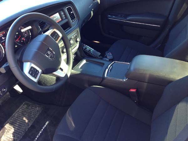 Interior view of a black Dodge Charger. Steering wheel, console, and seats are visible.