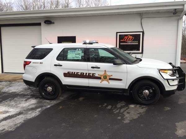White sheriff's SUV parked outside building; 