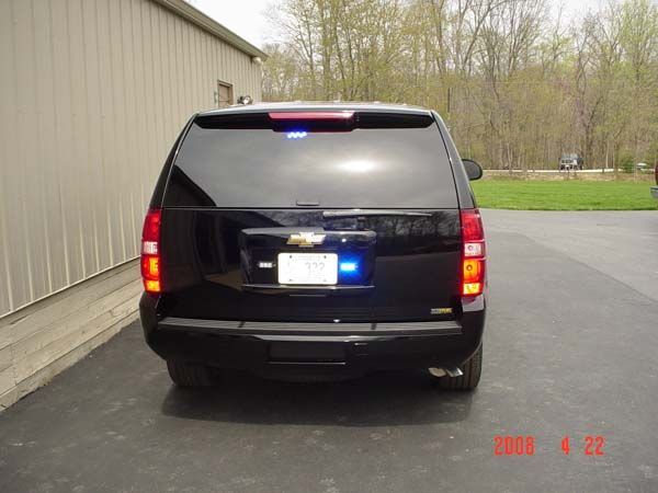 Black SUV with emergency lights, parked on a driveway.