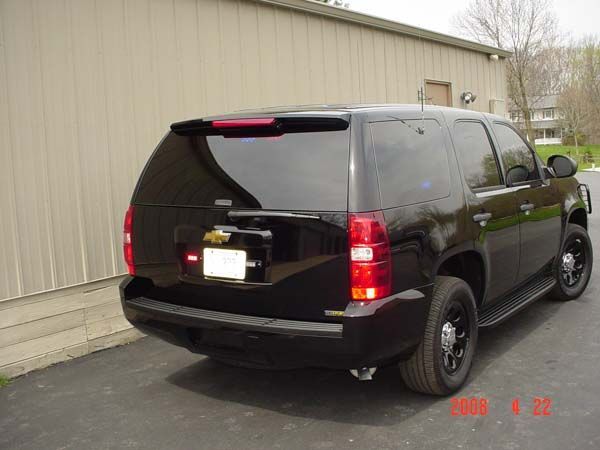 Black SUV parked outside, likely a police vehicle with dark tinted windows.