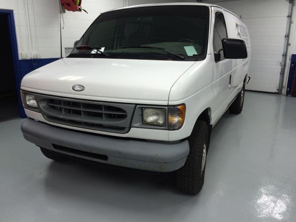 White Ford Econoline van parked in a garage.