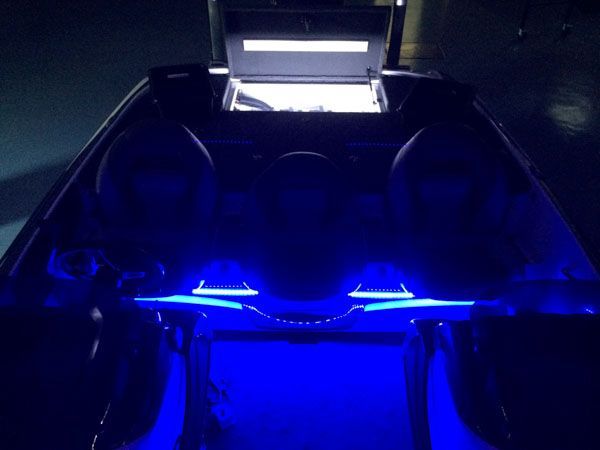 Dark interior of a vehicle, lit with blue and white lights.