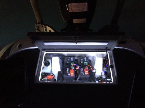 Boat engine compartment with lights illuminating various components and wiring.