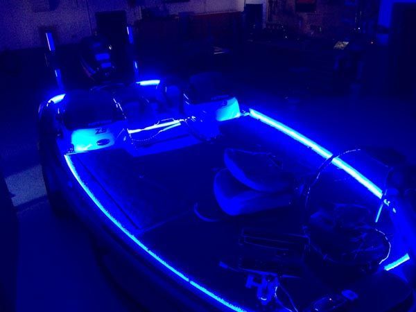 Blue neon lights illuminate a boat's interior at night.