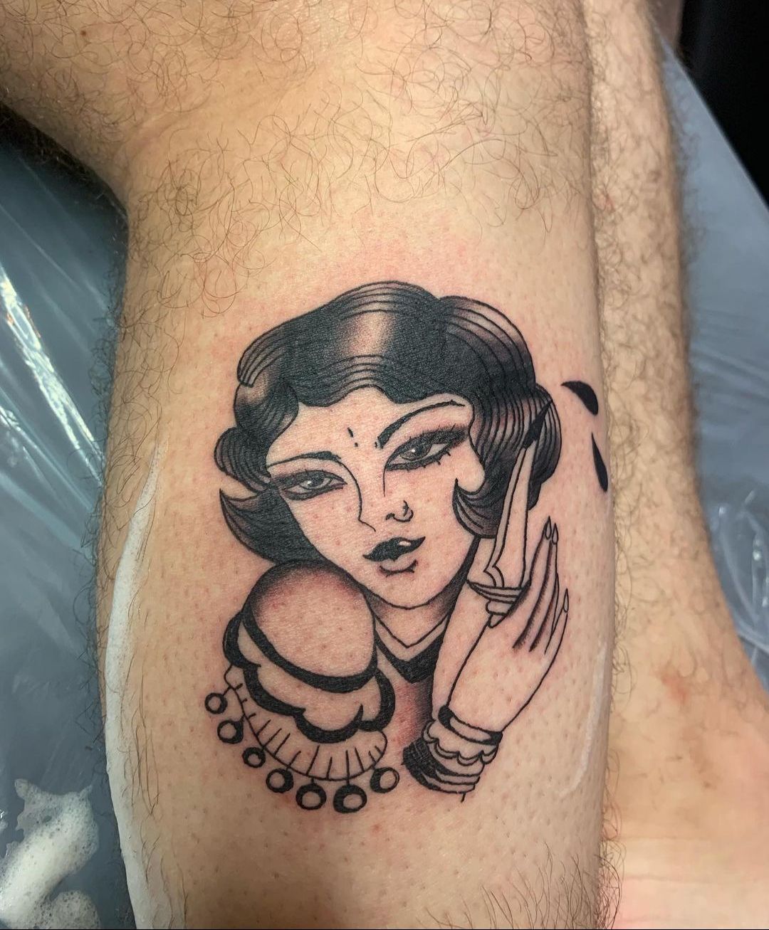 a man has a tattoo of a woman 's face on his leg