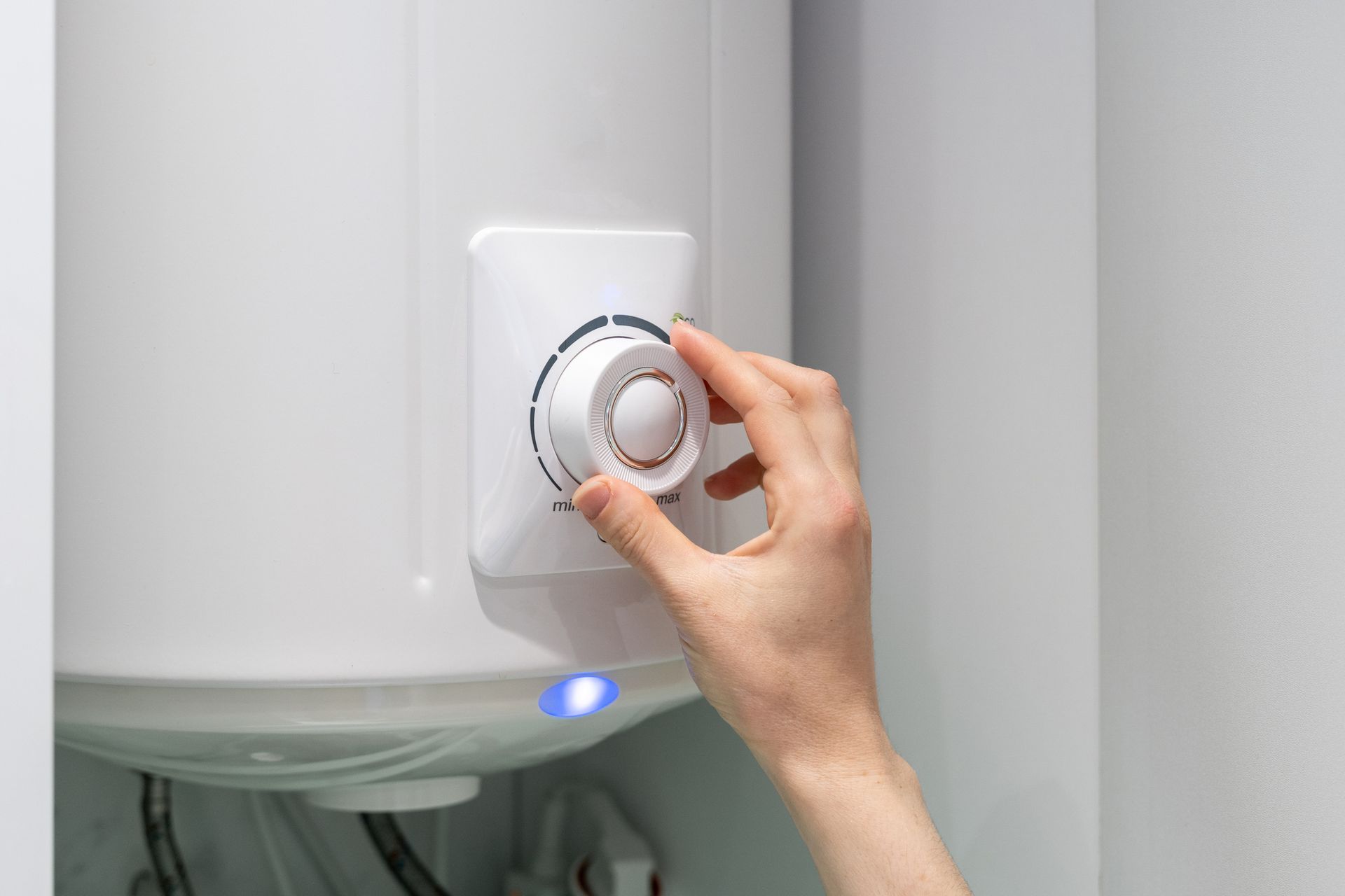 Person Adjusting Water Heater — Huntington, WV — Plumbing Helper