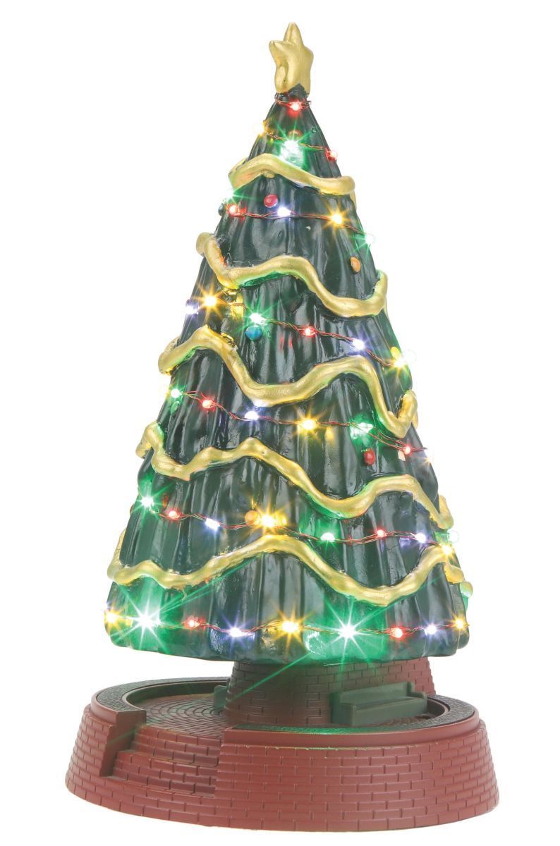 Small lit tabletop Christmas tree with green tinsel, gold garland, and a brick-like base