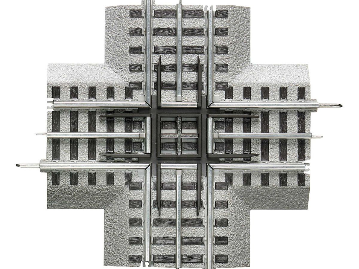 Top-down view of a gray industrial building with rail lines running through the center