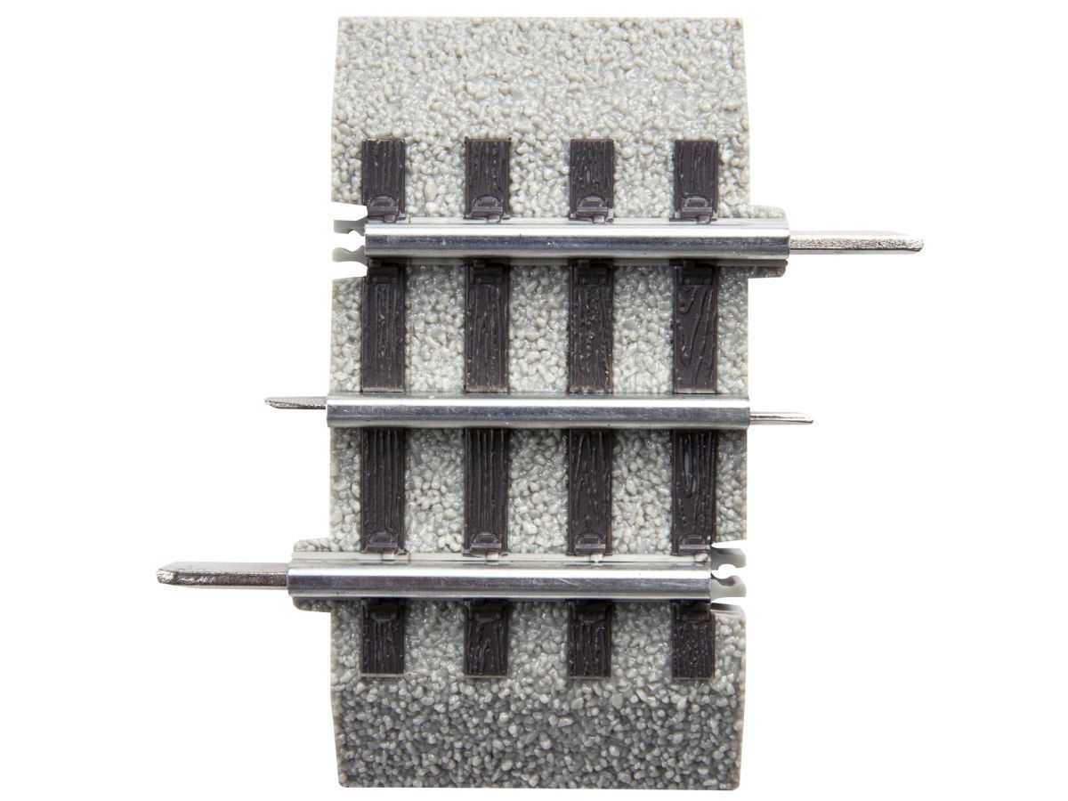 Railroad track section with three silver rails on gray ballast.